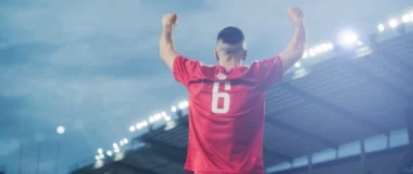 Jogador comemorando em um estádio de futebol